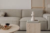 Kaboompics - Greige Linen Sofa with Sculptural White Vase on Travertine Pedestal Table