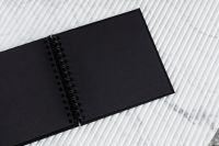 Kaboompics - Open Black Spiral Notebook on White Marble Desk, Overhead Minimalist Workspace