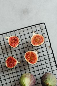 Kaboompics - Halved Figs On Black Cooling Rack With Whole Fruit