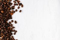Kaboompics - Coffee Beans Gathered Along the Left Side of White Textured Copy Space