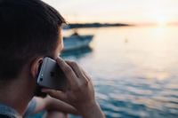 Kaboompics - Close-Up of a Man's Smartphone and Hand During a Seaside Call at Sunset