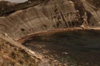 Kaboompics - Small Sandy Cove Beneath Steep Eroded Cliffs