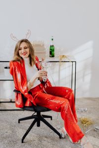 Kaboompics - Woman Relaxing in Red Suit beside a Festive Console Table