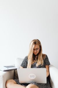 Kaboompics - Student Using Laptop with Notebook in an Armchair