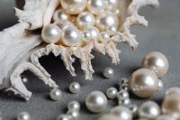 Kaboompics - Horizontal Close-Up of Pearls Spilling from a Seashell onto Gray Concrete