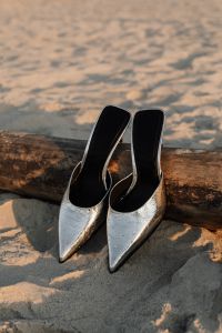 Kaboompics - Silver High Heels beside Driftwood on the Beach