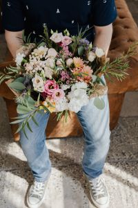 Kaboompics - Man Standing with Mixed Flower Bouquet, Navy Shirt and Light Jeans