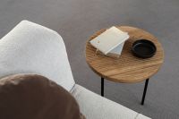 Kaboompics - Round Oak Side Table Beside a Bouclé Armchair