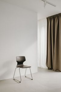 Kaboompics - Dark Sculptural Chair in Bright Room by Sheer Curtains