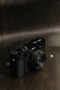 Kaboompics - Close-Up Fujifilm X100VI Camera on Dark Wood Surface