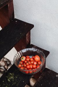 Kaboompics - Ripe Cherry Tomatoes in a Glass Bowl on Outdoor Wooden Steps