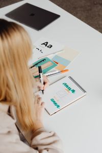 Graphic Designer at Work on Branding, Logo Sketches and Color Palettes in a Creative Workspace