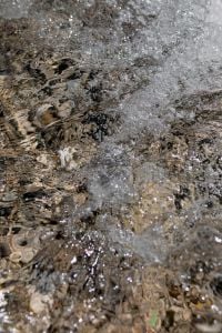 Kaboompics - Foamy Seawater Washing over Dark Pebbles on Rocky Beach