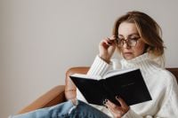 Kaboompics - Woman Reading the Bible at Home While Wearing Glasses