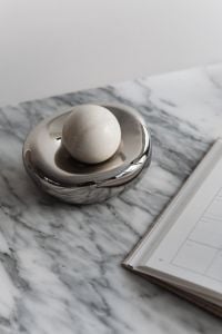 Kaboompics - White Round Object in Chrome Bowl beside Open Planner