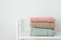 Kaboompics - Folded Pastel Sweaters on a White Rack