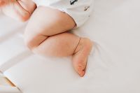 Kaboompics - Newborn Baby's Bare Feet and Bent Legs on White Bedding