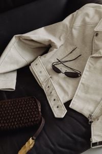 Kaboompics - Beige Jacket, Sunglasses and Woven Bag on a Leather Sofa