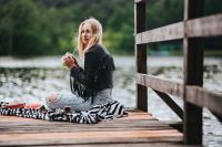 Kaboompics - Blonde woman having a healthy snack at the wooden pier