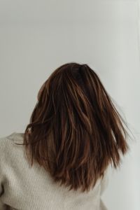 Kaboompics - Hand Touching Brown Hair in a Neutral Beauty Close-Up