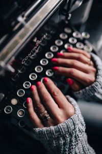 Woman typing on an old typewriter