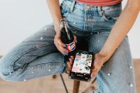 Kaboompics - Smartphone Screen and Cola Bottle in a Seated Woman's Hands, Casual Home Lifestyle Detail