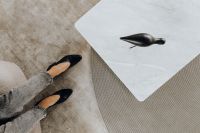 Kaboompics - Black Leather Heel and Sculptural Bird on Marble Coffee Table, Neutral Interior Fashion Detail