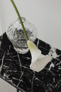 Kaboompics - White Calla Lily and Textured Glass Vase on Black Marble Table, Minimalist Interior