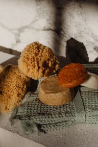 Kaboompics - Close-Up of Natural Sea Sponges and Handmade Soap Bars on Green Towel