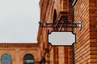 Kaboompics - Blank Hanging Store Sign beneath Manufaktura Wall Sign, Łódź, Poland