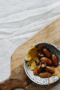 Kaboompics - Bowl of Acorns on a Wooden Board and White Linen