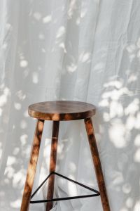Kaboompics - Round Wooden Stool in Front of White Linen Curtains