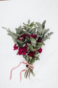 Kaboompics - Burgundy Carnations and Eucalyptus Wrapped in Pink Ribbon, White Marble Floral Gift Still Life
