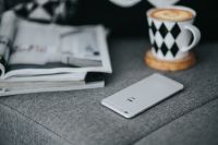 Kaboompics - Close-Up Smartphone and Coffee Cup beside Open Magazines