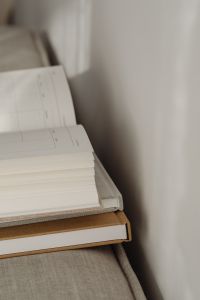 Kaboompics - Open Planner Pages on Stacked Notebooks, Neutral Sofa with Copy Space