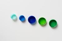 Kaboompics - Five Colorful Plastic Bottle Caps Arranged in a Row