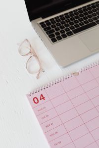 Kaboompics - Close-Up of Pink Calendar, Laptop Keyboard and Glasses for Minimal Workspace Content