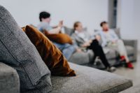 Kaboompics - Gray Sofa Detail with Brown Accent Cushion and Visitors in a Furniture Showroom