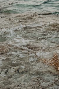 Kaboompics - Vertical Close-Up of Foamy Waves Over Pale Coastal Rocks