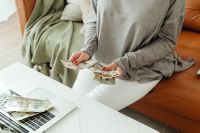 Kaboompics - Woman Holding Bitcoin Coins Beside Laptop