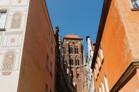 Kaboompics - Gdańsk Old Town Tower Between Orange Facades and Painted Townhouse Wall