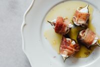 Kaboompics - Stuffed Figs Wrapped In Prosciutto On White Plate