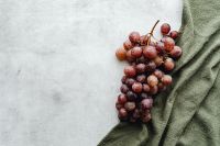 Kaboompics - Close-Up Red Grapes on Travertine with Olive Green Linen