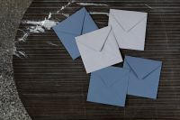 Kaboompics - Blue and White Envelopes on a Round Black Marble Table, Overhead Stationery Scene