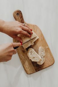 Kaboompics - Slicing Bread on a Wooden Paddle Board