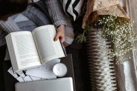 Kaboompics - A woman in a sweater reads a book