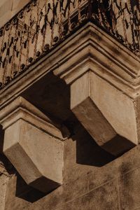 Kaboompics - Close-Up of Weathered Stone Cornice and Ornate Ironwork