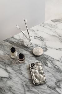 Kaboompics - Toothbrushes, Cosmetics and Silver Phone on Arabescato Marble