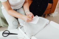 Kaboompics - Hand-Tying Natural Twine Around Tissue-Wrapped Boutique Purchases