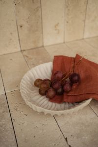 Kaboompics - Red Grapes and Rust Napkin in Ceramic Dish